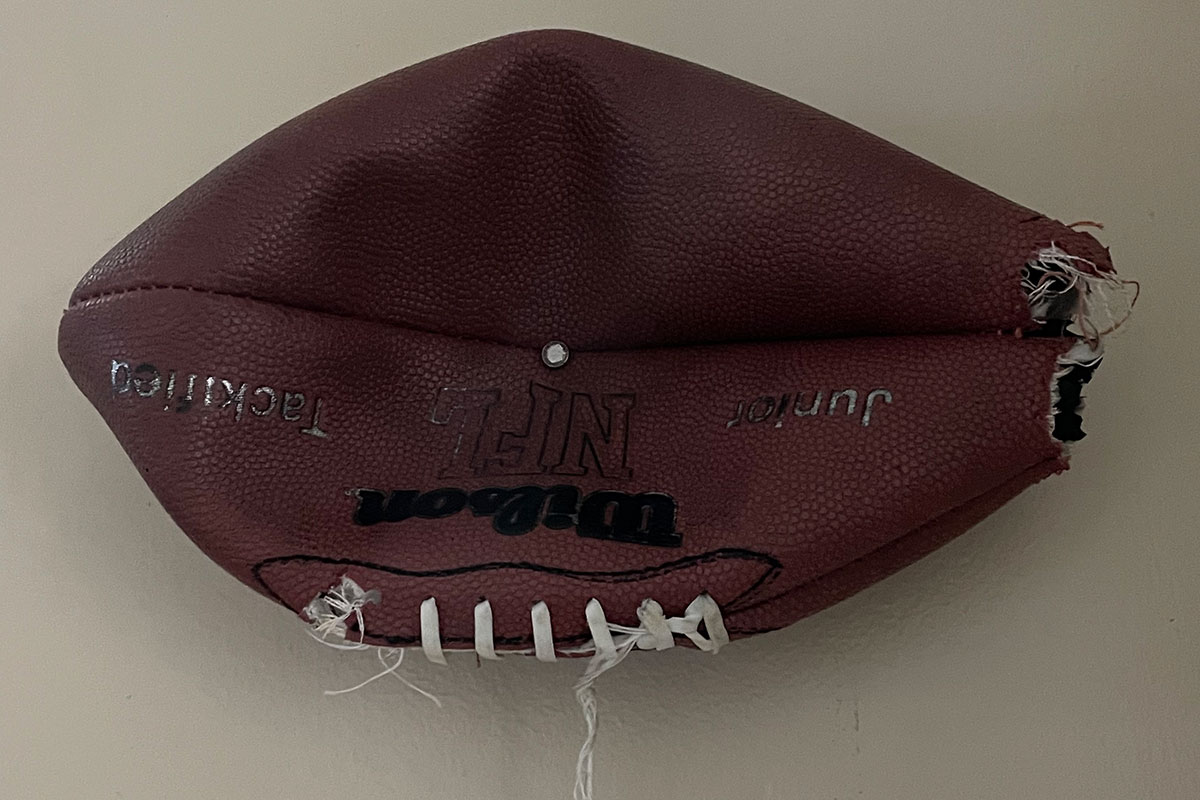 A deflated football nailed to the wall.