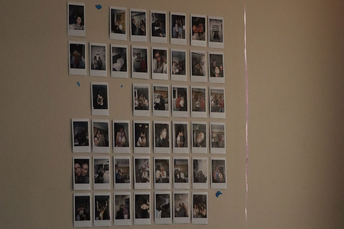 Many polaroid photos are stuck to the wall.