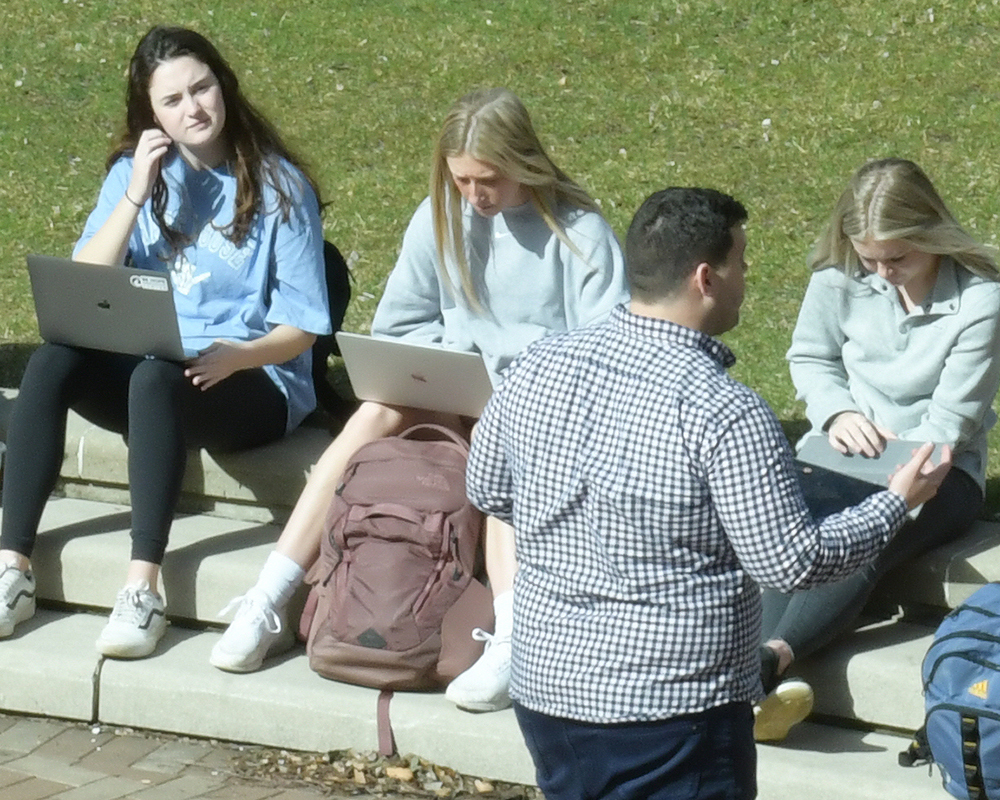 A class is held outdoors on a warm, sunny day