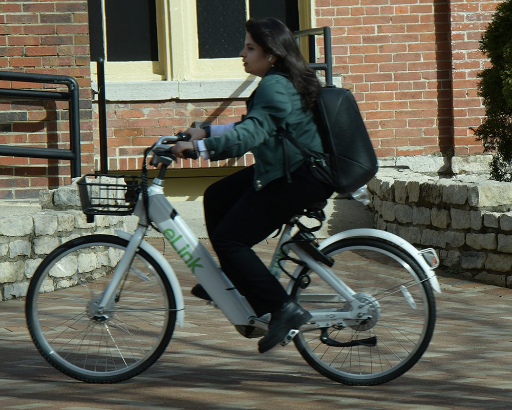 A person rides a bicycle on a sunny day