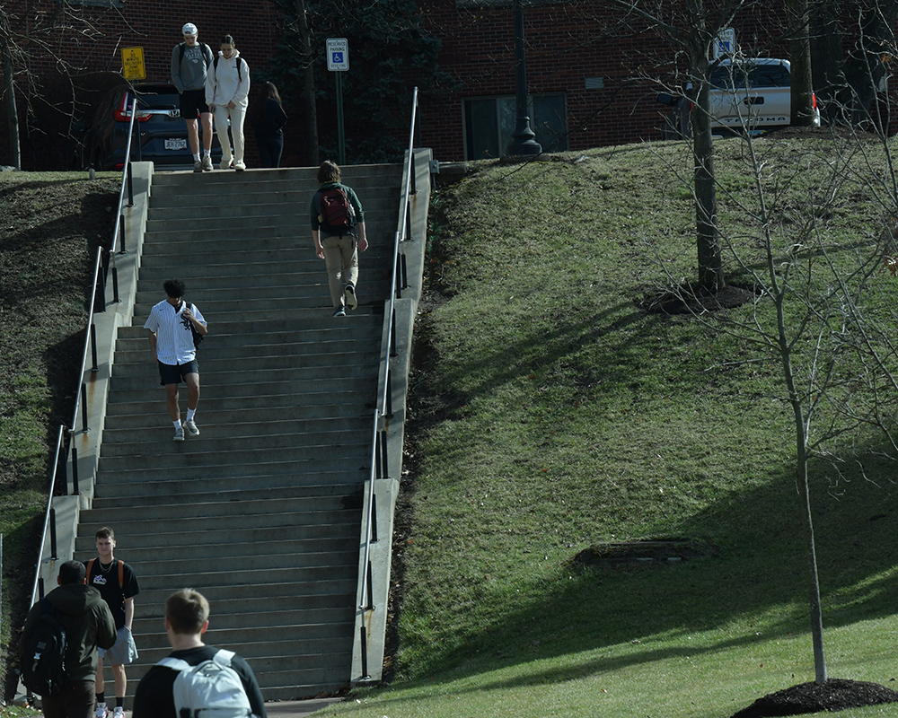 Students walk up the stairs at class change on a warm day