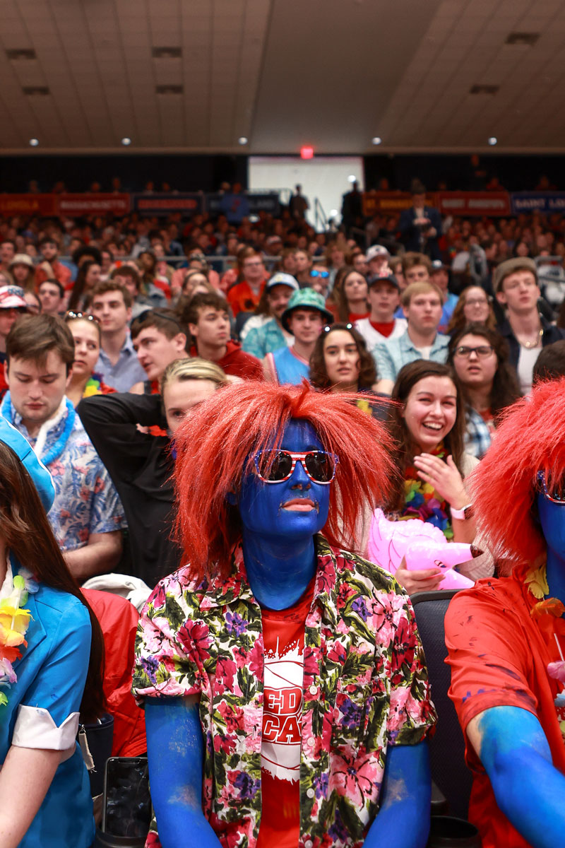 Red Scare student in a red wig sits among a sea of Dayton Flyer fans