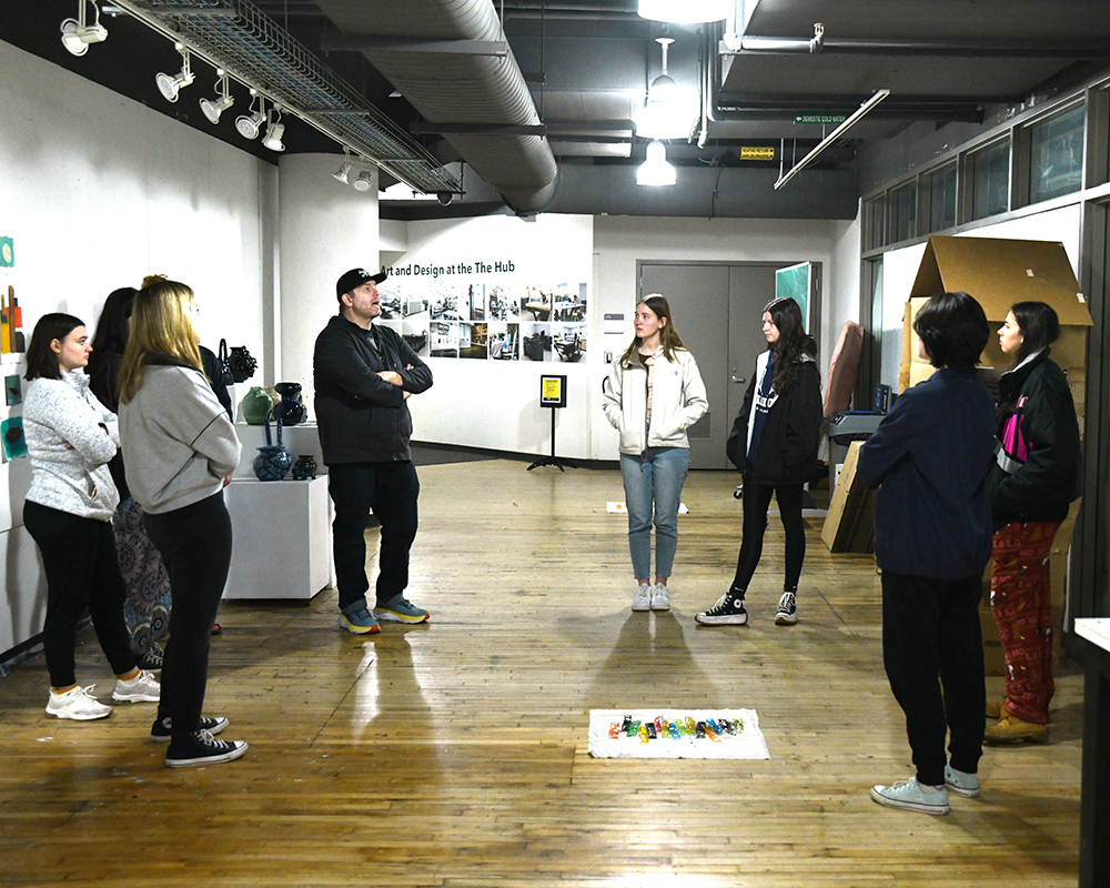 A visual arts instructor talks to his students