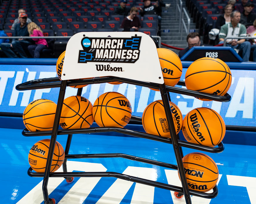 A rack of basketballs bears the March Madness logo.