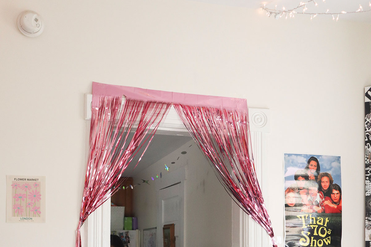 Sparkling pink door curtain tassels and a "That 70s Show" poster.