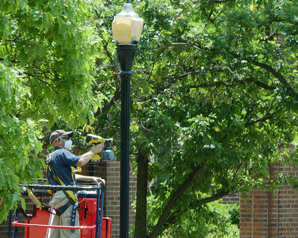 Workers painting a light pole
