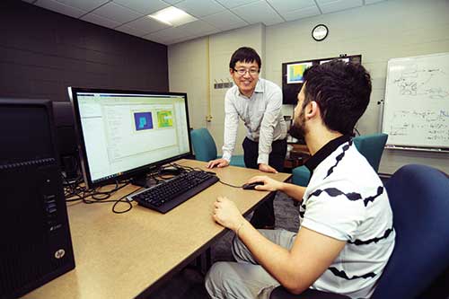 Hirakawa working with a student in the sensors lab.