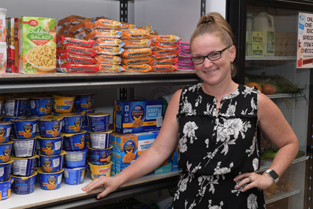 Kristen Keen stands next to a shelf of food