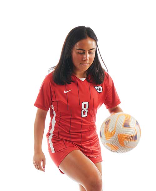 Soccer player Diana dribbles a soccer ball on her knee.