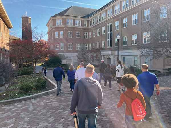 A group of students walks around campus on a tour.