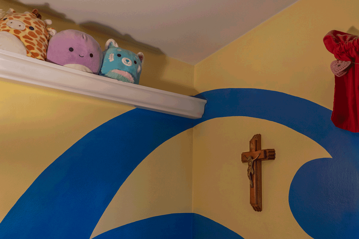 A crucifix hangs on the wall of Maggie's bedroom