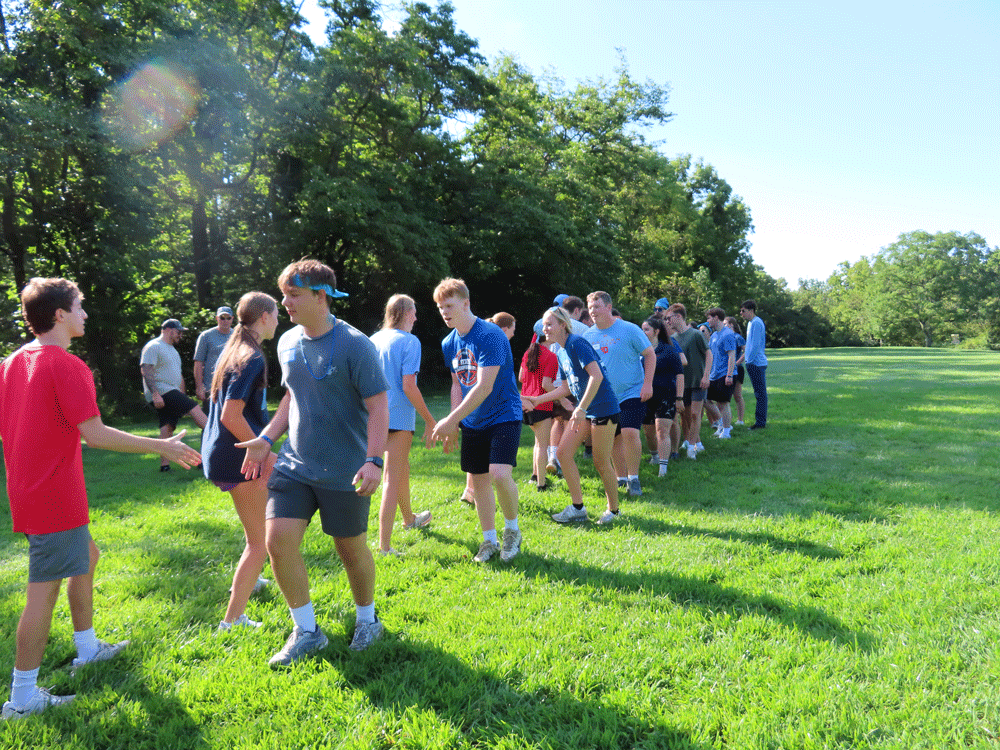 Students stand in two lines giving each other high fives during a game.