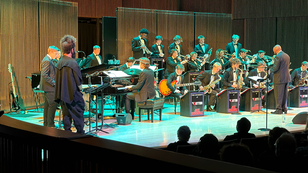 Trumpet player Ashlin Parker stands off to the side of the stage at the UD Jazz Ensemble plays together.
