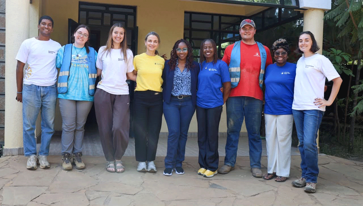 Kuebler and the other students pose in front of the Dandelion Africa Building