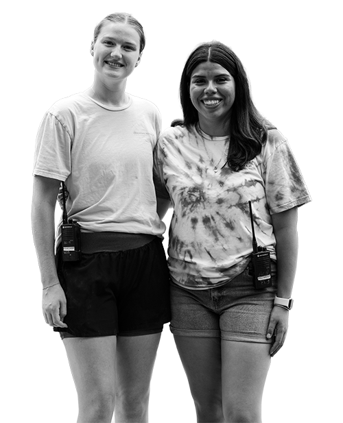 Two women pose for the camera with arms around each other, smiling.