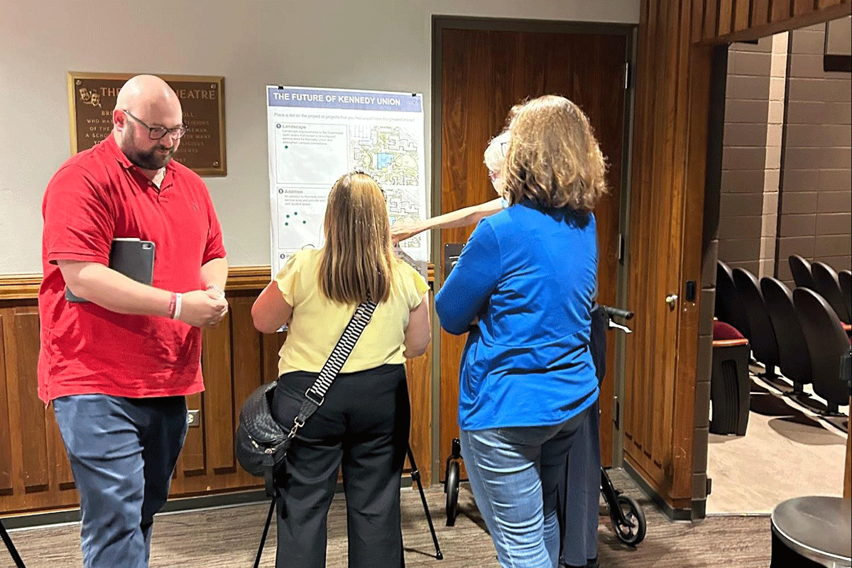 Faculty and staff members place stickers on large posters that feature ideas of the new Master Plan.