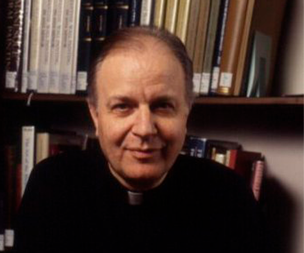 A head and shoulders shot of Father Johann Roten, S.M. in front of a bookcase.