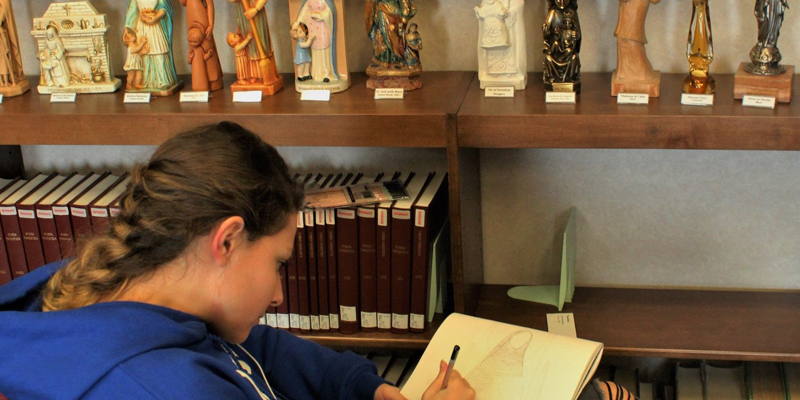 student sketching statues in the reading room