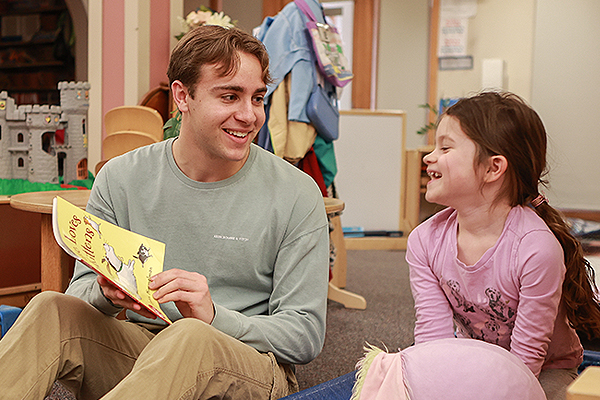 UD student Jack Hutter reads to a child in a Bombeck Family Learning Center classroom