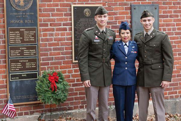 Kelly family stand beside UD ROTC Honor Roll plaque