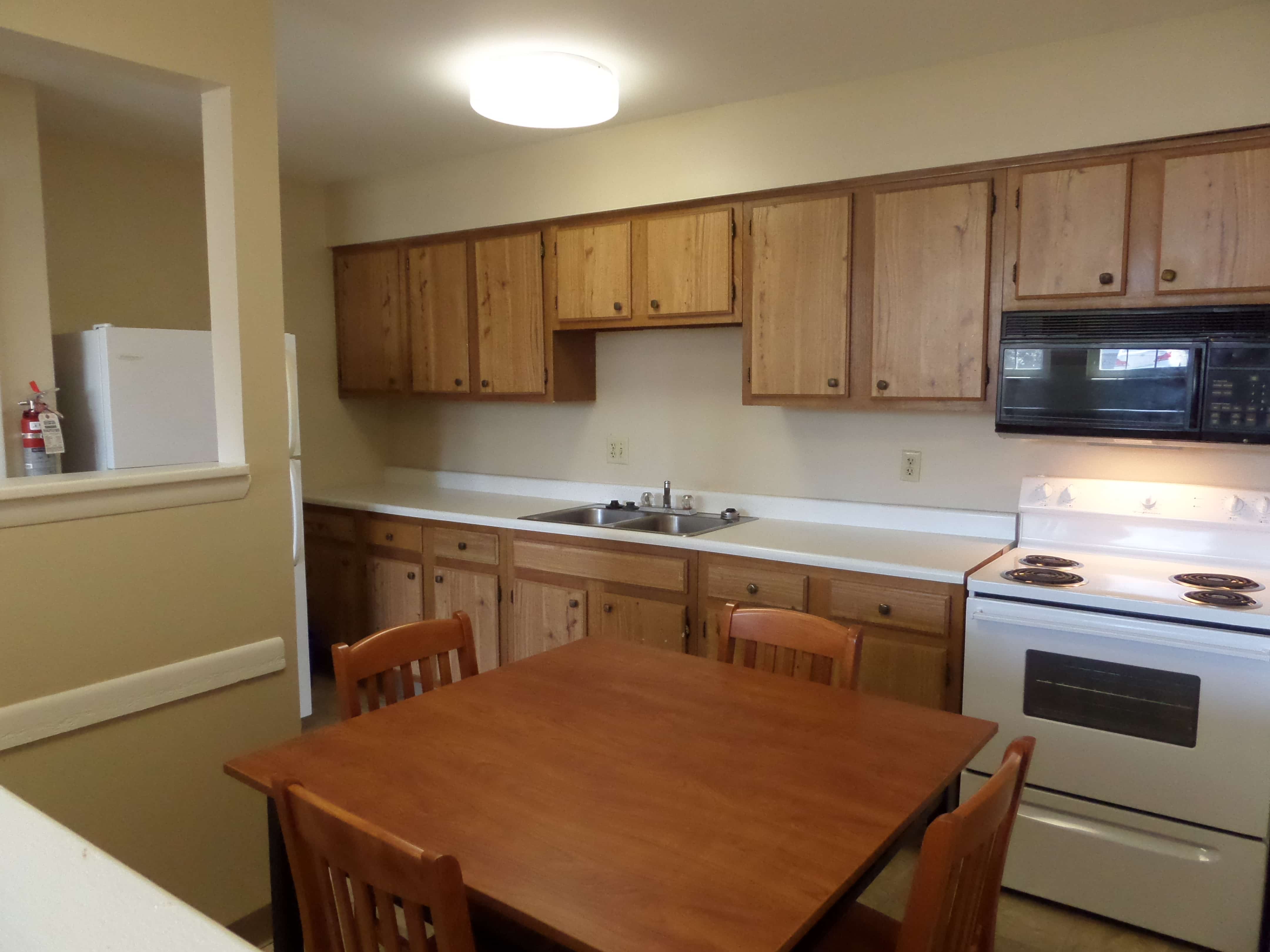 Spacious kitchen, with large fridge, microwave, stove, dining table and chairs