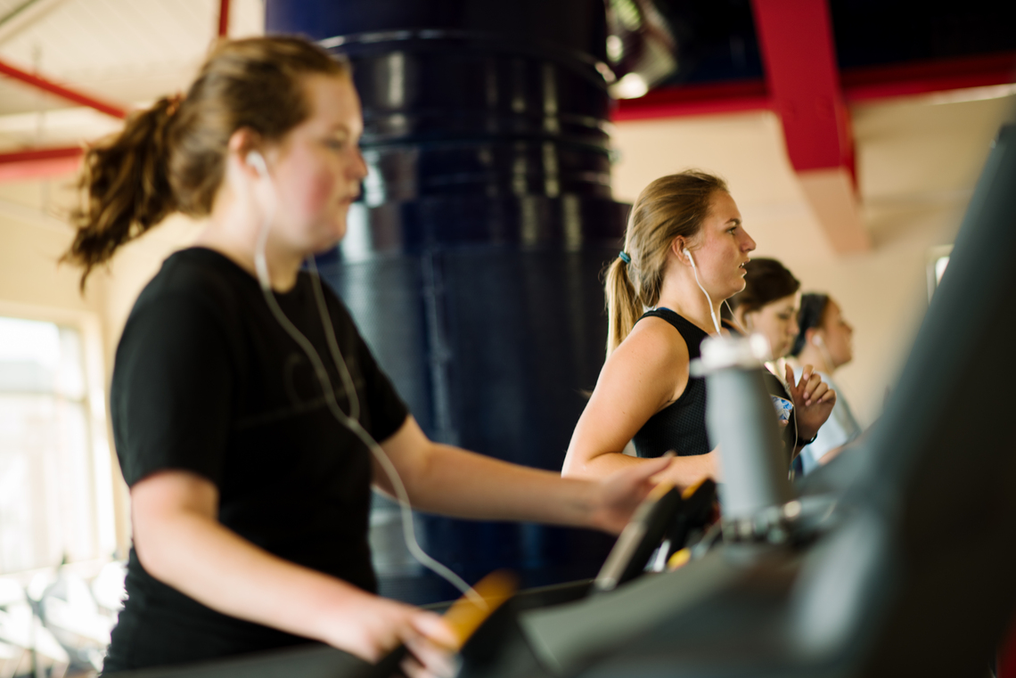 Four female students on treadmills on the Fitness Level of the RecPlex.