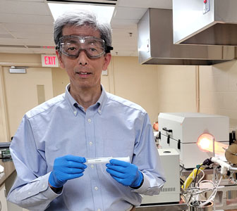 Principal Environmental research engineer Tak Yamada holds a PFAS sample for testing.